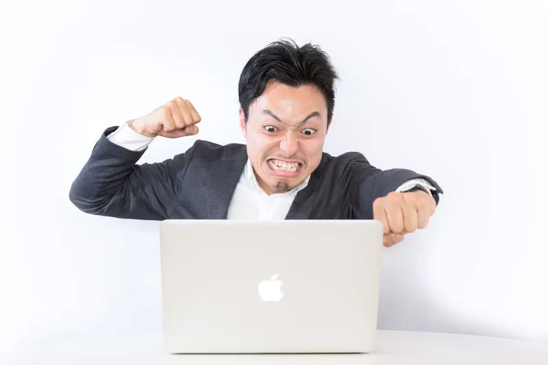 パソコンに怒りを露わにする男性